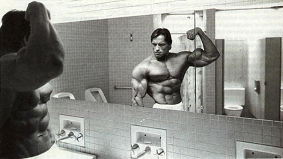 Arnold flexing in front of the mirror