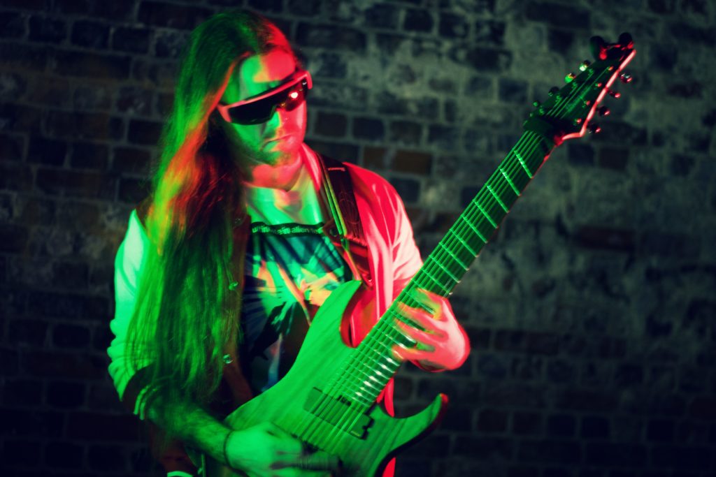 Fan Octo plays 8-string guitar wearing pit viper sunglasses