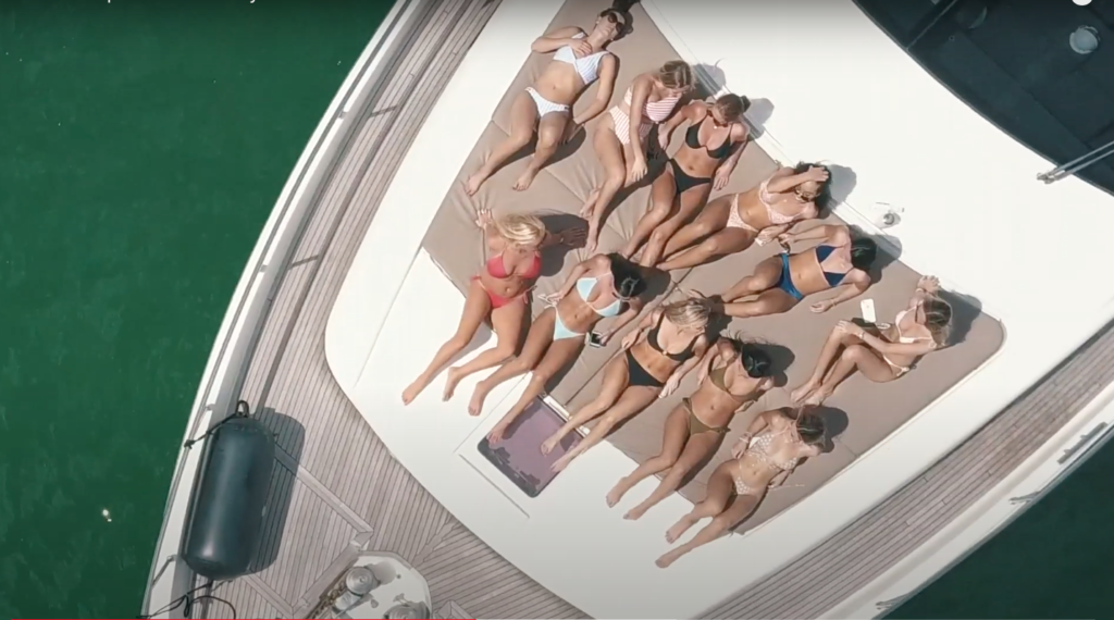 Girls from Delta Phi Epislon sunbathe on a boat in Miami, FL.