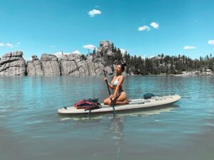 Cute girl paddles on inflatable water craft