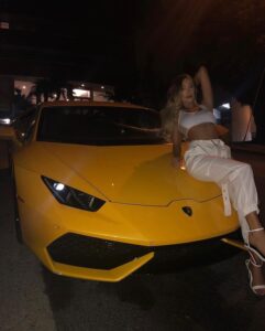 Georgia Valentina leans back on a yellow luxury sportswear