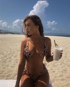 Georgia Valentina drinks a refreshing cocktail on the beach